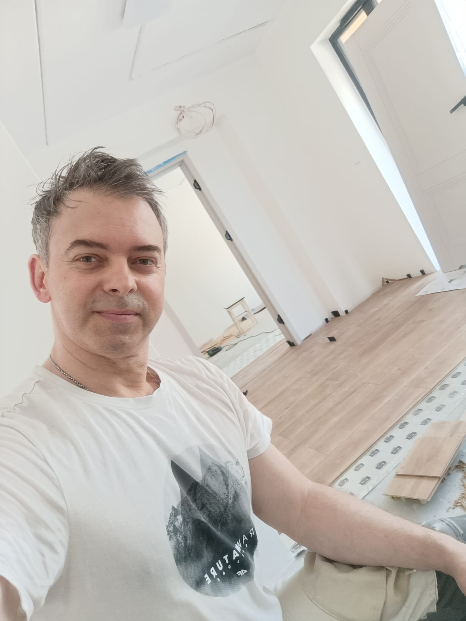 Andrzej Klimczak z DomMalowanie.pl na remoncie w Katowicach, w tle świeżo ułożone panele